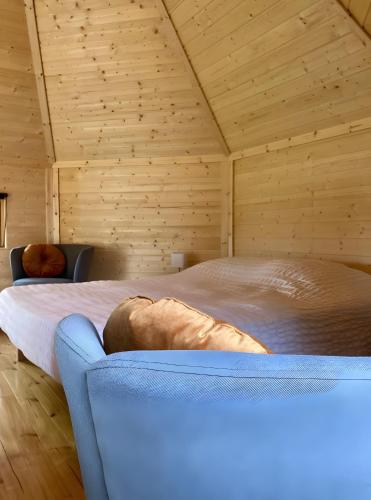 a bedroom with a large bed in a wooden room at Le Kota Du Paradou in Givet