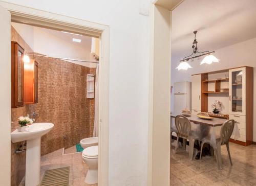 a bathroom with a sink and a table with chairs at Villa Tramonto Ionico Torre Lapillo in Torre Lapillo