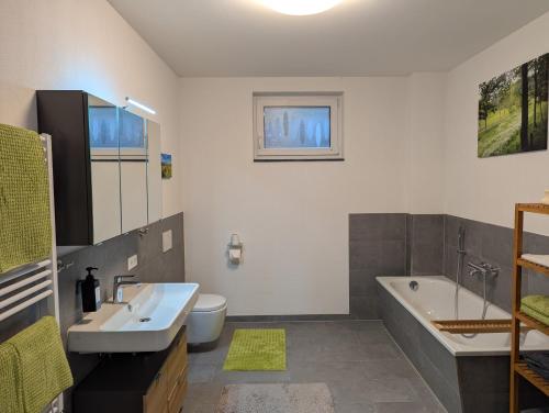 a bathroom with a sink and a tub and a toilet at Schiller´s Urban Escape in Freudenstadt