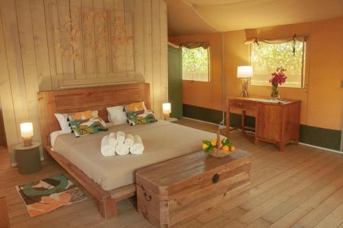 a bedroom with a large bed with shoes on it at Glamping Alcantara in Motta Camastra