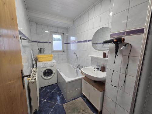 a bathroom with a washing machine and a sink at Regenhäusl Waldbach in Arrach