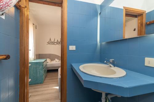 a blue bathroom with a sink and a tub at Villa Maffy in Baja Sardinia