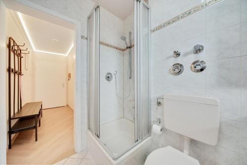 a white bathroom with a shower and a toilet at Zuhause am Kurgarten in Bad Reichenhall