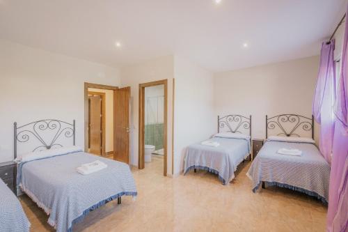 a room with two beds and a bathroom at El Cauce in Navaluenga