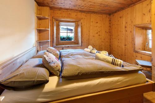two beds in a room with wooden walls at Chalet di Mont in Valfurva