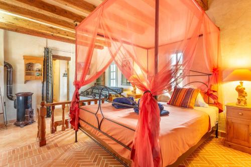 a bedroom with a canopy bed with red drapes at Oasis San Martin El Cotillo in El Cotillo