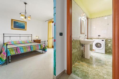 a bedroom with a bed and a sink and a washing machine at La Pineta in SantʼAntìoco
