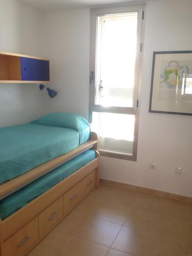 a small bedroom with a bed and a window at La Azohía Espacio en Calma in La Azohía