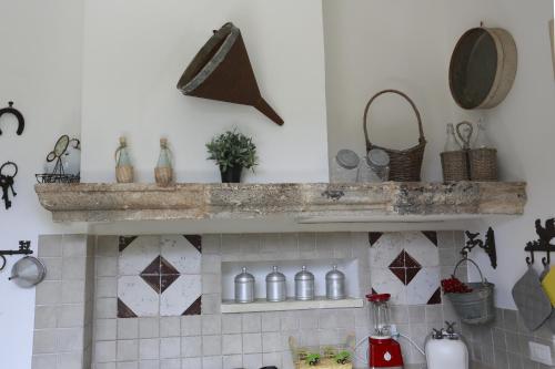 a kitchen with a shelf with bottles on it at Villa Dina in Nardò