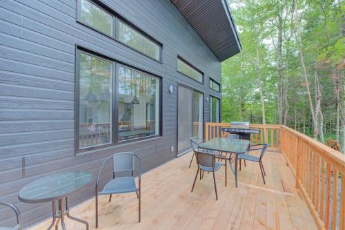 a porch with a table and chairs on a deck at La Relache - Nature & Relaxation - Pet Friendly in Pont-Rouge