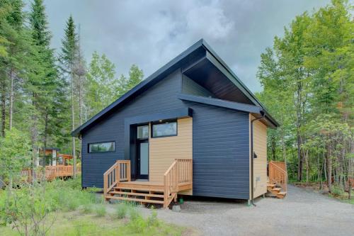 a black and yellow tiny house in the woods at La Relache - Nature & Relaxation - Pet Friendly in Pont-Rouge
