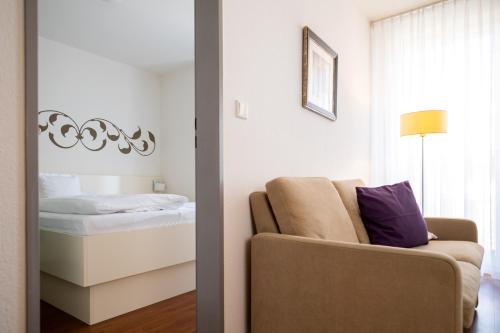 a bedroom with a bed and a couch and a mirror at Ferienhaus Jümmers - Jomtje in Horumersiel