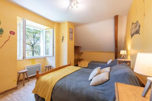 a bedroom with a large bed with pillows on it at Gite Dans Grange Foraine - Baou in Artalens-Souin