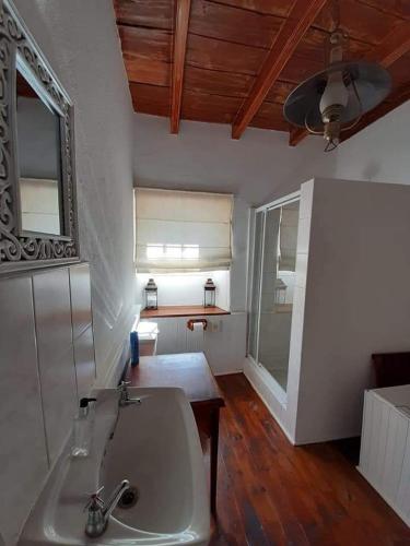 a bathroom with a sink and a mirror at De Kothuize 16 in Graaff-Reinet