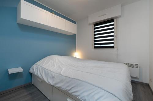 a bedroom with a white bed and a window at Le Sailing,parking, proche plage in Arzon