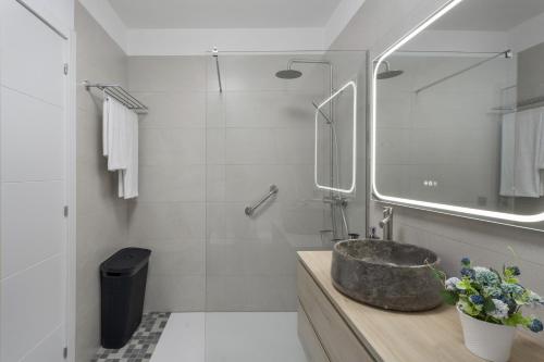 a bathroom with a stone sink and a mirror at Apartamento Calecampo in Candelaria