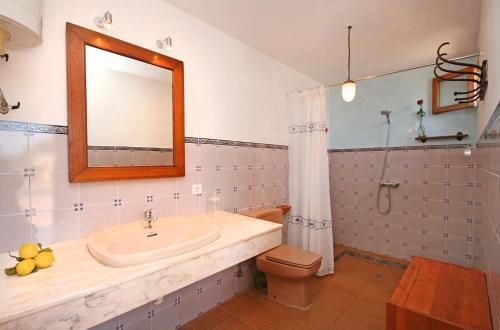 a bathroom with a sink and a toilet and a mirror at S'hort des Cura in Islas Baleares