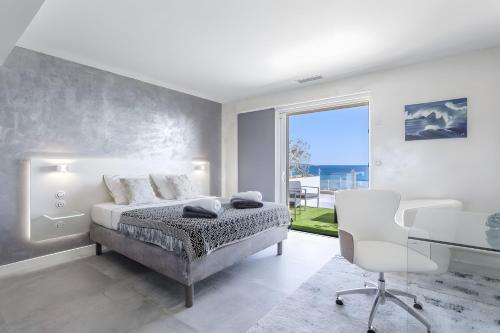 a bedroom with a bed and a desk and a window at Villa Baraka in Sainte-Maxime