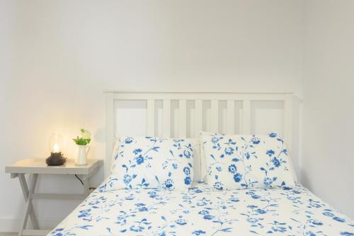 a bed with blue and white sheets and pillows at Vela in Arrecife
