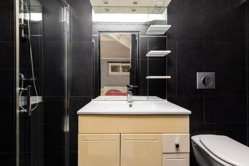 a bathroom with a sink and a mirror and a toilet at Maison De Vacances 8pers Seignosse in Seignosse