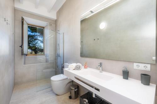 a bathroom with a sink and a toilet and a mirror at Son Crespi Vell in Manacor