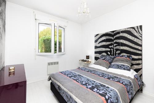 a bedroom with a bed with a black and white headboard at Maison De Vacances 8pers Seignosse in Seignosse