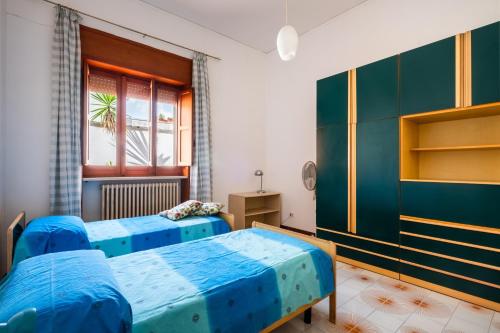 two blue beds in a room with a window at Salento Home in Cursi