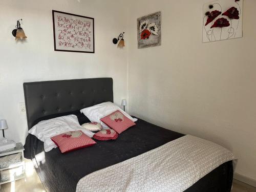 a bedroom with a bed with red pillows on it at Mas de Maussan in Robion en Luberon