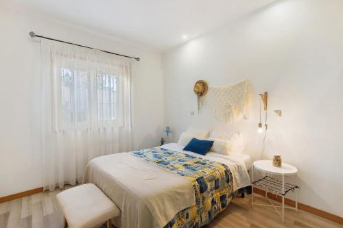 a white bedroom with a bed and a window at Tour House in Rio Tinto