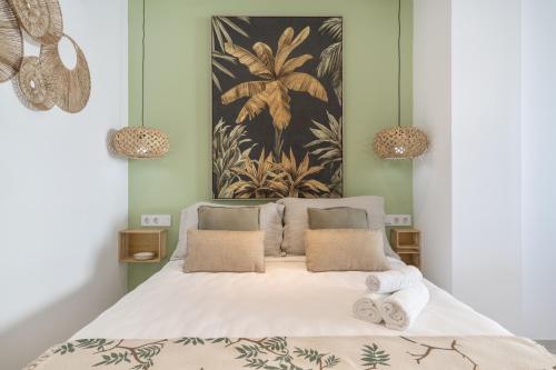 a bedroom with a bed with white sheets and pillows at Apartamento The Banana Tree 2 9 in Tarifa