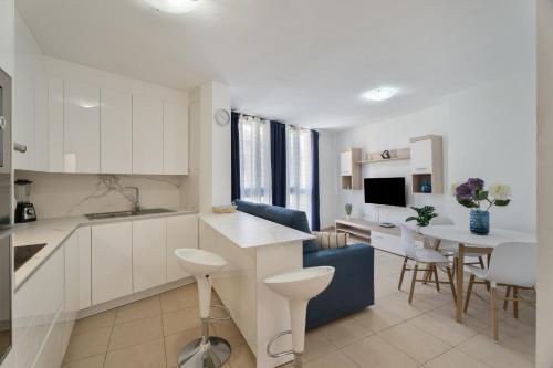 a kitchen with white cabinets and a dining room at Apartamento Estrella in Candelaria