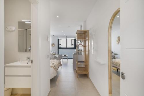a white bathroom with a sink and a mirror at Apartamento The Banana Tree 2 9 in Tarifa