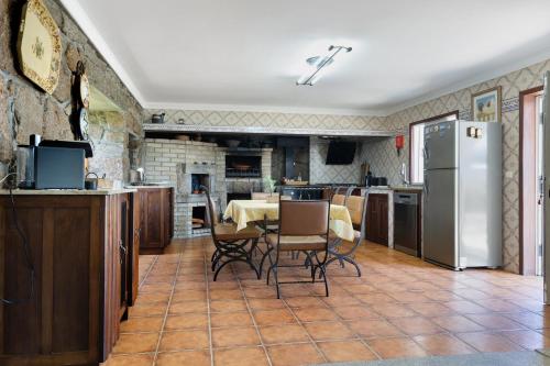 a kitchen and dining room with a table and a refrigerator at Quinta do Rio Douro - Turismo Rural in Paços de Gaiolo
