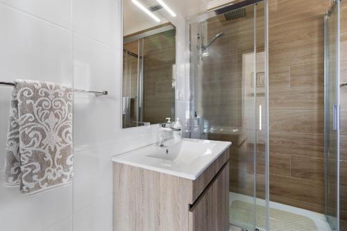 a white bathroom with a sink and a shower at Quinta do Rio Douro - Turismo Rural in Paços de Gaiolo