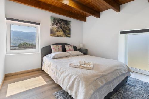 a bedroom with a large bed and a large window at Quinta do Rio Douro - Turismo Rural in Paços de Gaiolo