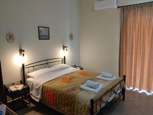 a bedroom with a bed with two towels on it at Evgenia Rooms in Skala