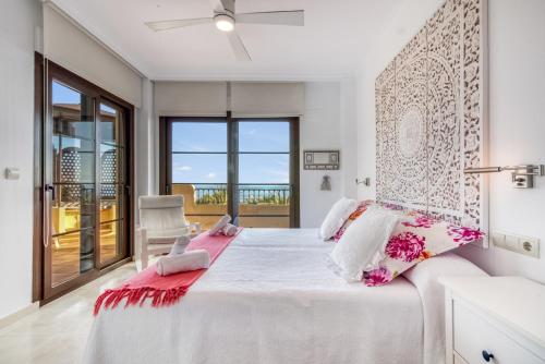 a bedroom with a large white bed with pink accents at Gadea Vistas in Caserío Capnegret