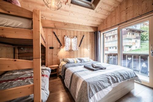 a bedroom with two bunk beds and a window at Chalet Stéphane centre chatel in Châtel