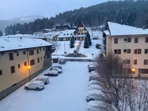 a group of cars parked in a parking lot covered in snow at Dúplex acogedor en La Molina- 8 Pax in La Molina