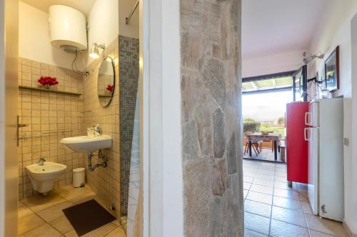 a bathroom with a sink and a refrigerator at Pergola 707 in Stintino