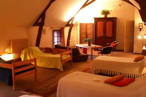 a room with two beds and a living room at Gites Du Château De Saveilles in Paizay-Naudouin