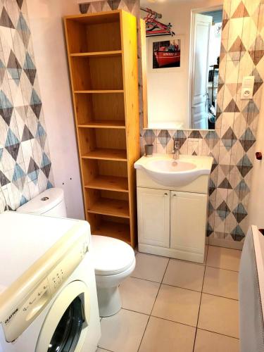 a bathroom with a toilet sink and a washing machine at Maison De Plage La Payade in Pirou