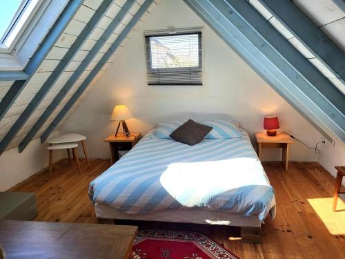 a bedroom with a bed and two tables and a window at Maison De Plage La Payade in Pirou