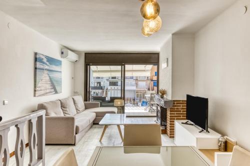 a living room with a couch and a tv at Port Empúries in Empuriabrava