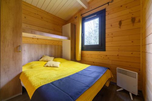 a bedroom with a bed in a wooden cabin at Chalet Spa 2 Terrasse des Bouleaux in Ranspach