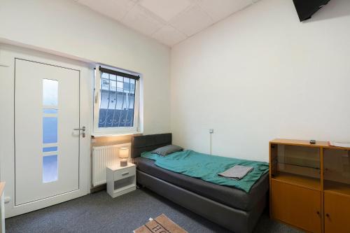 a small bedroom with a bed and a window at Cozy 2-bed Room With Kitchen W2 in Beckingen