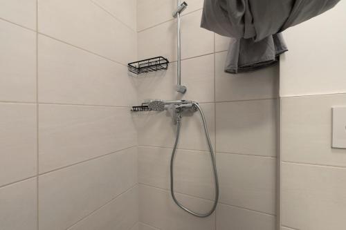 a shower with a hose in a bathroom at Cozy 2-bed Room With Kitchen W2 in Beckingen