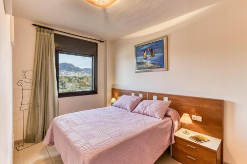 a bedroom with a bed and a window at Roses Apartaments Luxury Duplex in Roses