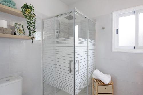 a glass shower in a white bathroom with a window at Casa Valista in Tijarafe
