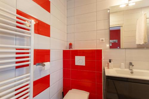 a red and white bathroom with a toilet and a sink at Chambre - Joubarbe in Aroue